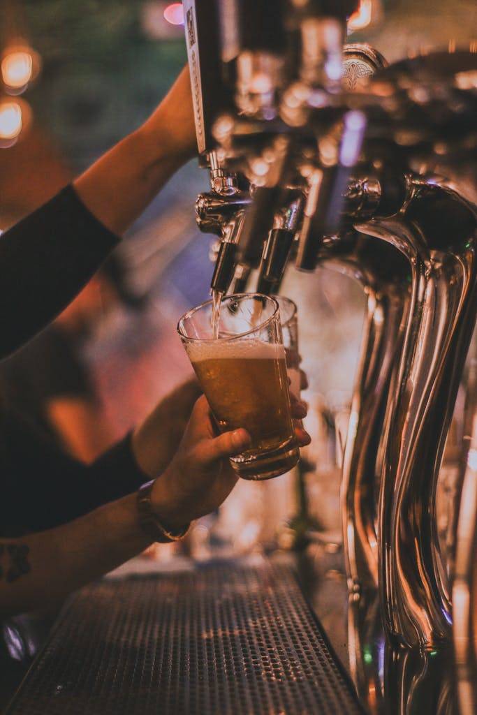 A Hand Refilling Beer on the Glass